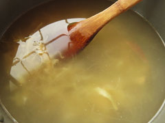 玉ねぎを炒めた鍋に水とコンソメを入れる