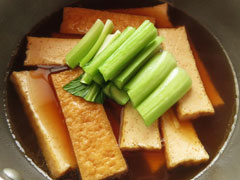 厚揚げを煮ている鍋に小松菜の茎を入れる。
