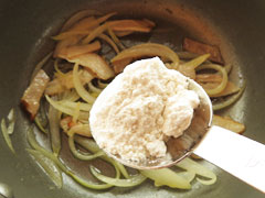 ベーコンと玉ねぎを炒めている鍋に、小麦粉大さじ1を加える。