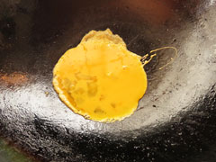 熱したフライパンに溶き卵を入れる。