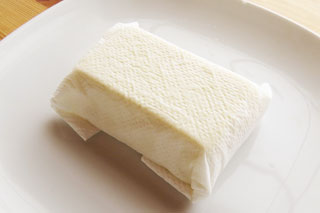 塩をふってキッチンペーパーに包んだ絹ごし豆腐。