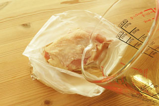 鶏胸肉の入ったビニール袋にブライン液を注ぐ。