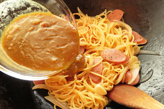 調味料をくわえてざっと炒めたスパゲティに残りカレーをくわえる。