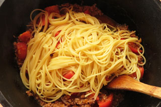 フレッシュトマトのミートソースの入った鍋にゆでたスパゲティを入れる。